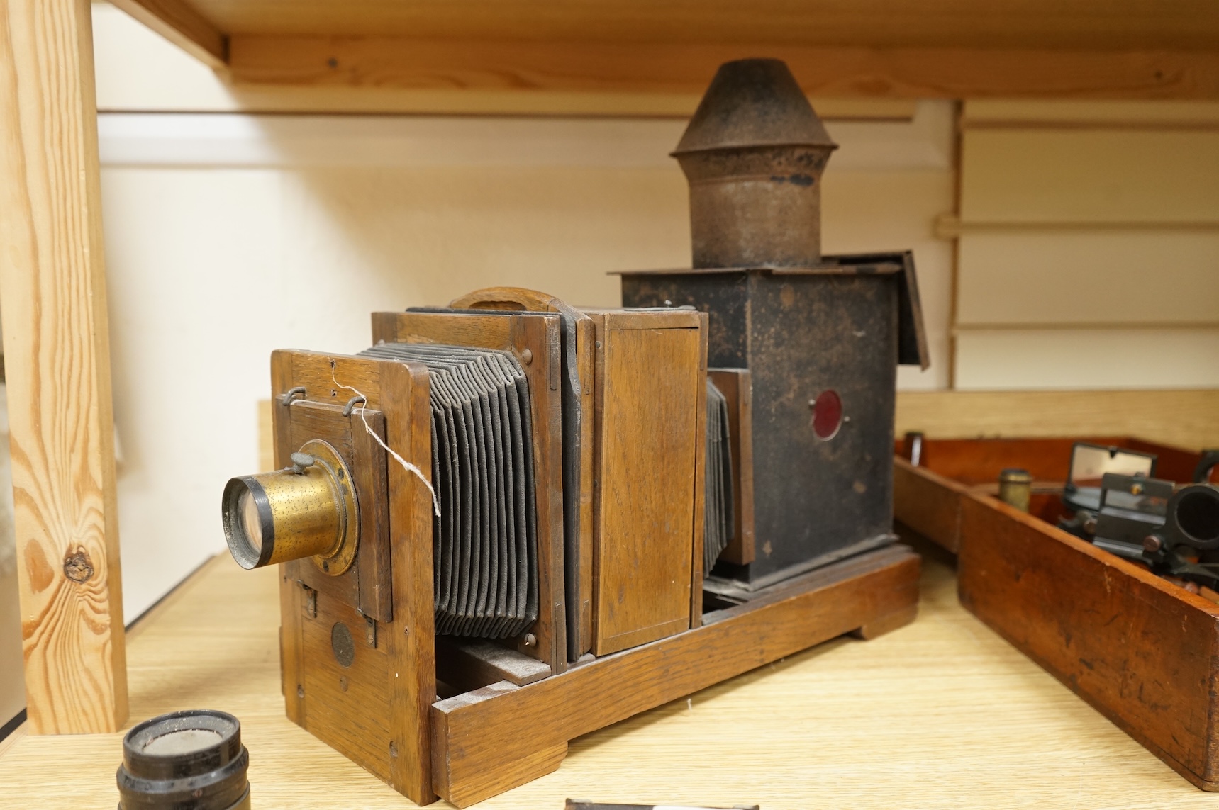 A late 19th century mahogany and tinplate magic lantern style horizontal photograph enlarger, together with some related items.